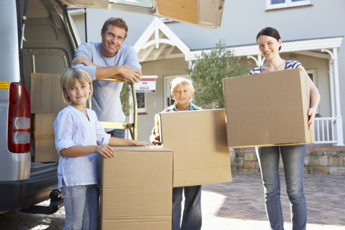 Moving crew handling packed boxes during a house relocation